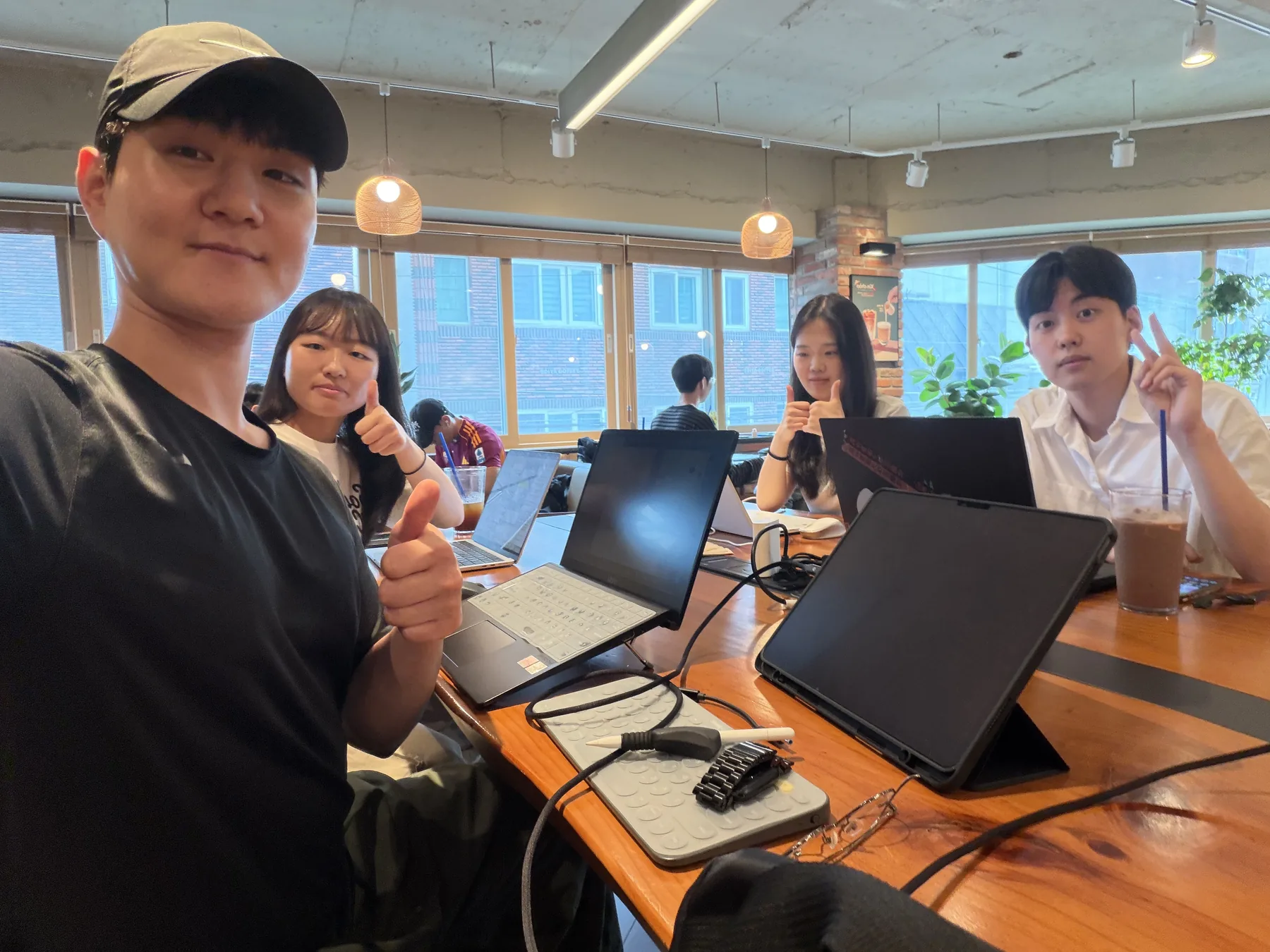 핀로그 구성원들이 카페에서 노트북과 태블릿을 펼쳐 놓고 함께 작업한 모습